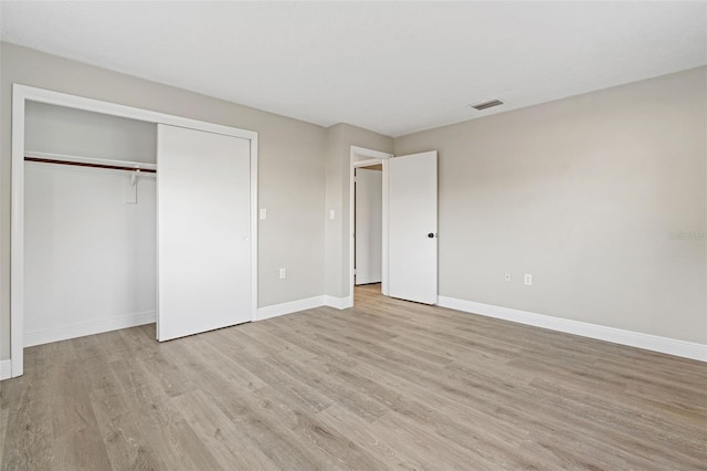 unfurnished bedroom featuring a closet and light hardwood / wood-style flooring