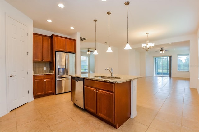 kitchen featuring sink, a center island with sink, ceiling fan with notable chandelier, and appliances with stainless steel finishes