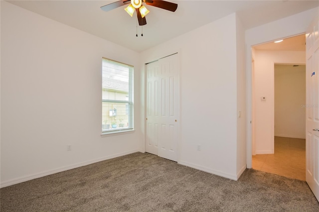 unfurnished bedroom with carpet flooring, ceiling fan, and a closet