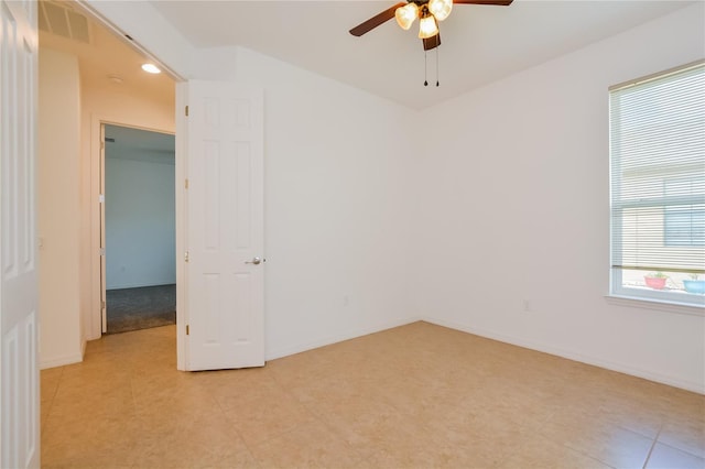 spare room with ceiling fan and light tile patterned floors