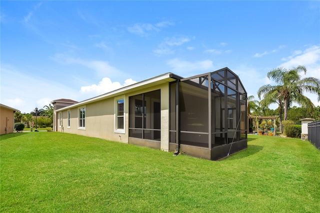 rear view of house with a lawn and a lanai