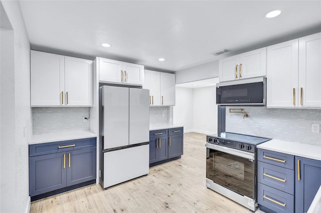 kitchen with blue cabinets, light wood-type flooring, white cabinets, and appliances with stainless steel finishes