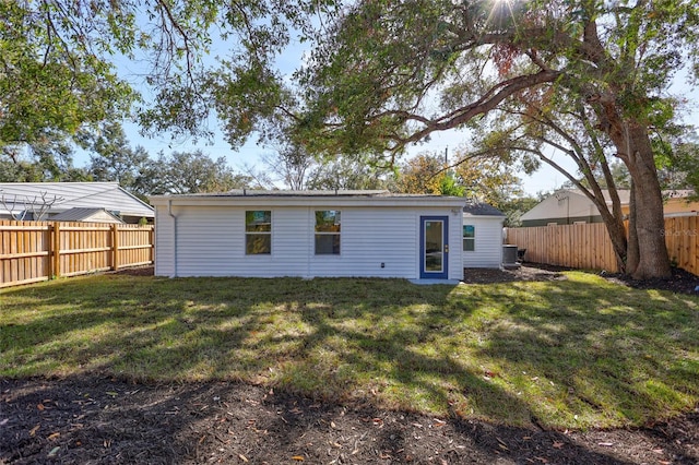 rear view of property with a yard and central AC