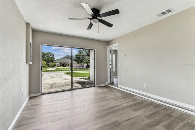 102 Shore Dr E, Oldsmar, FL 34677 - spare room with wood finished floors, ceiling fan, and a textured ceiling