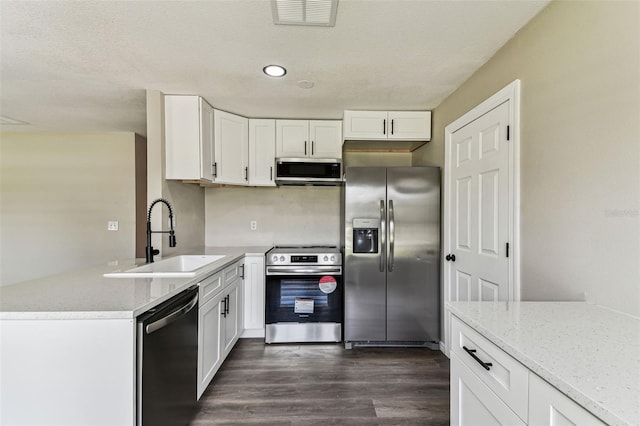 102 Shore Dr E, Oldsmar, FL 34677 - kitchen featuring stainless steel appliances, dark wood finished floors, white cabinetry, light stone counters, and recessed lighting