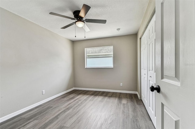 102 Shore Dr E, Oldsmar, FL 34677 - empty room with wood finished floors, a textured ceiling, and ceiling fan