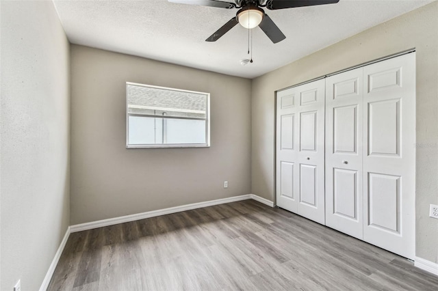 102 Shore Dr E, Oldsmar, FL 34677 - unfurnished bedroom with wood finished floors, a closet, and a ceiling fan
