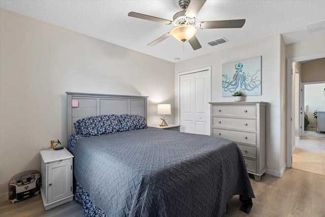 bedroom featuring light wood-type flooring, a closet, and ceiling fan