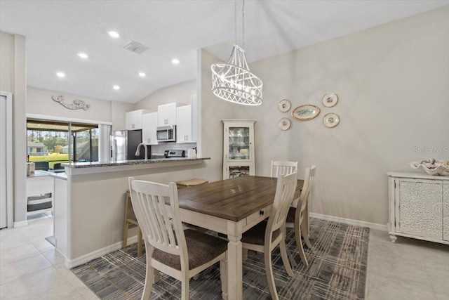 dining area featuring light tile patterned flooring, lofted ceiling, and sink