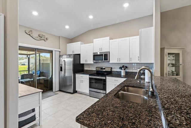 kitchen with sink, white cabinets, stainless steel appliances, and vaulted ceiling