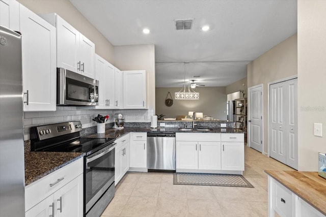 kitchen featuring white cabinets, sink, kitchen peninsula, and stainless steel appliances