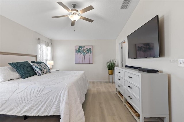 bedroom featuring ceiling fan, light hardwood / wood-style floors, and vaulted ceiling