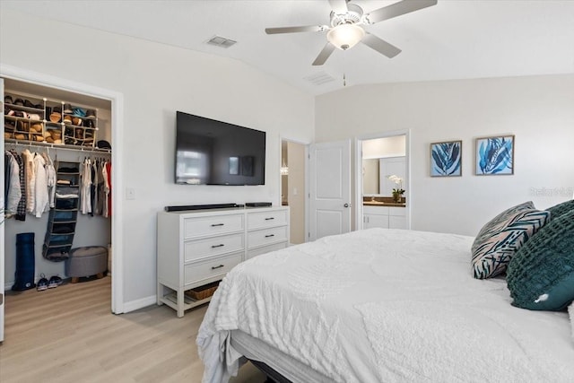 bedroom with a walk in closet, ensuite bath, ceiling fan, light hardwood / wood-style floors, and lofted ceiling