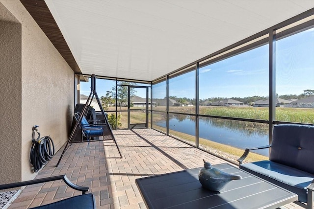 unfurnished sunroom featuring a water view and plenty of natural light