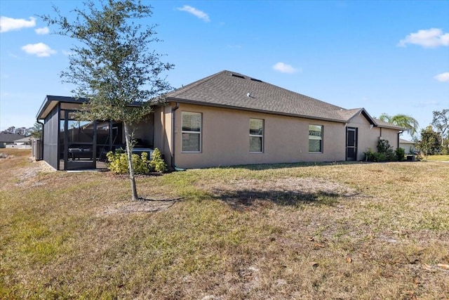 rear view of property featuring a yard and a sunroom