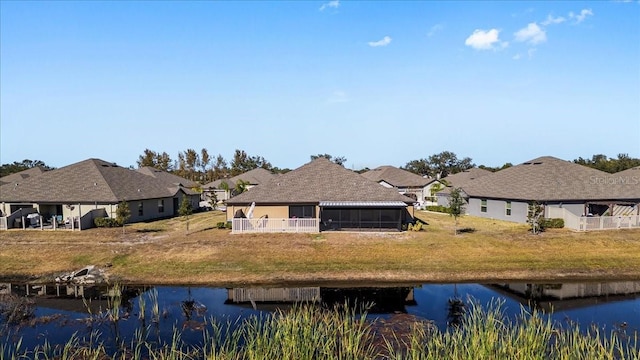 back of house with a water view and a sunroom