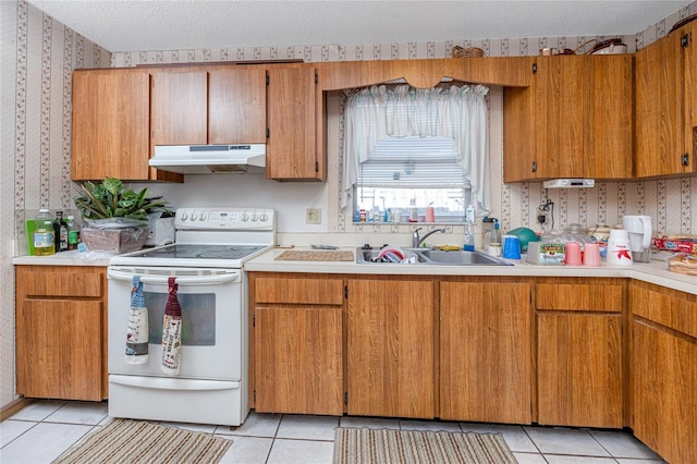 kitchen featuring a textured ceiling, white range with electric stovetop, and light tile patterned flooring