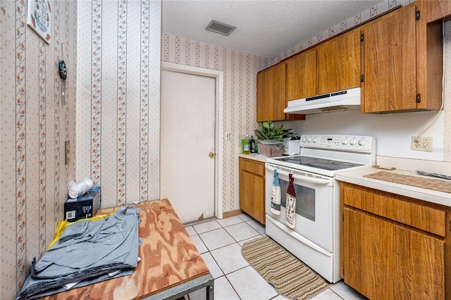 kitchen with light tile patterned floors, a textured ceiling, and white electric stove