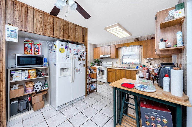 kitchen with ceiling fan, sink, light tile patterned floors, and white appliances