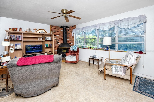 living room with a wood stove and ceiling fan