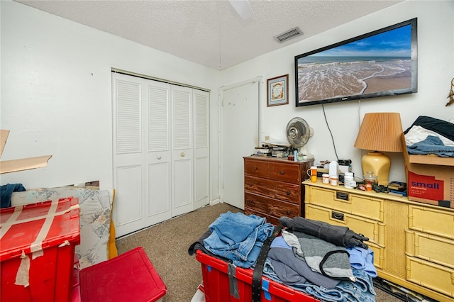 carpeted bedroom featuring ceiling fan, a textured ceiling, and a closet