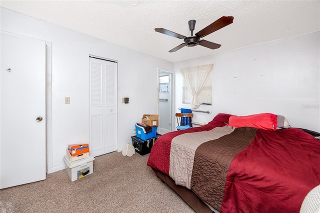 carpeted bedroom featuring ceiling fan, a textured ceiling, and a closet