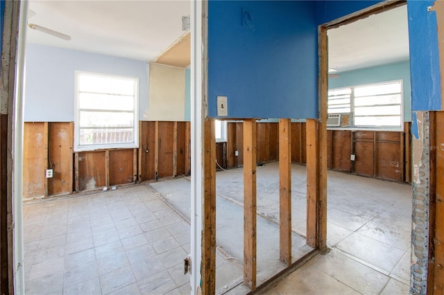 corridor with a wealth of natural light and wood walls