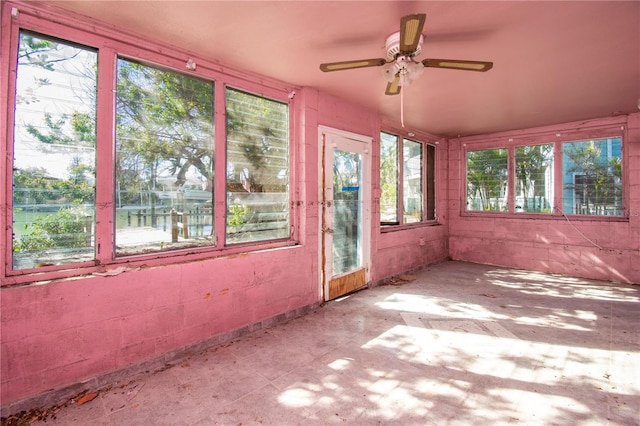 unfurnished sunroom featuring ceiling fan