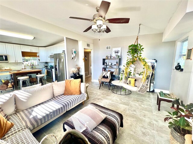 living room featuring ceiling fan and sink