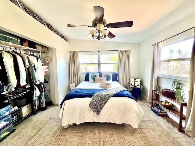 bedroom with a closet, ceiling fan, and light colored carpet