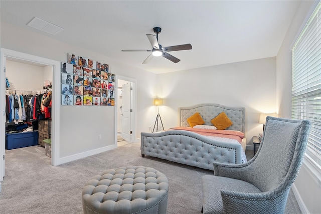 carpeted bedroom with a closet, a spacious closet, and ceiling fan