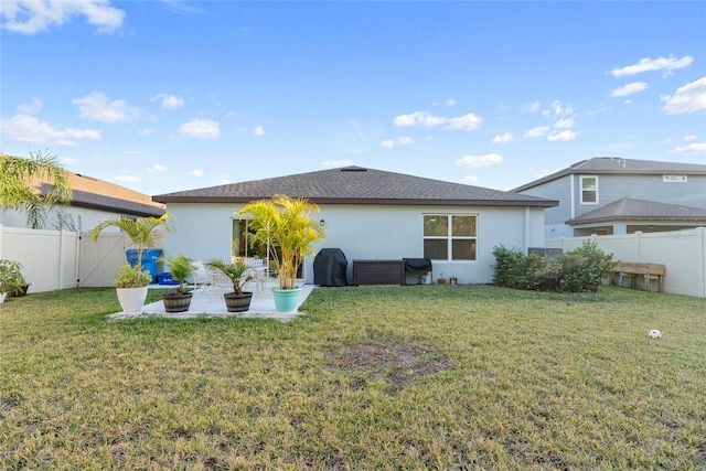 rear view of house with a yard and a patio