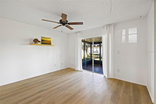 spare room with a textured ceiling, light hardwood / wood-style floors, and ceiling fan