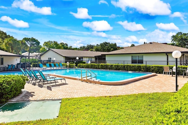 view of swimming pool featuring a yard and a patio area