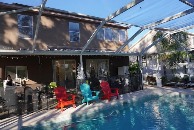 view of swimming pool featuring a lanai and a patio area