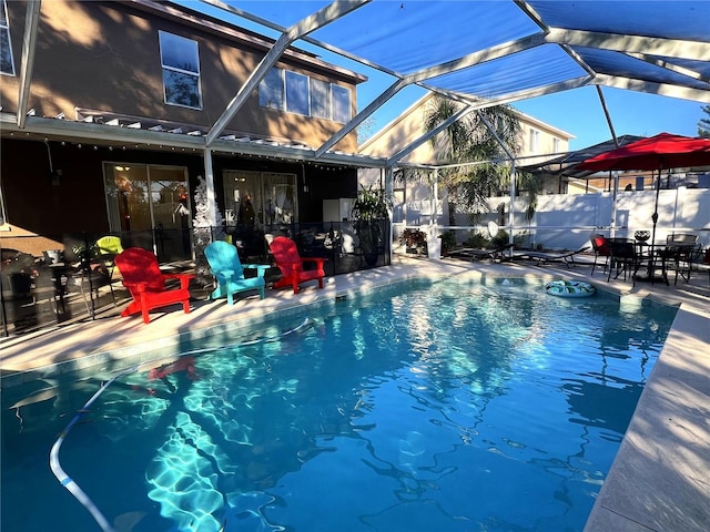 view of swimming pool featuring a lanai and a patio