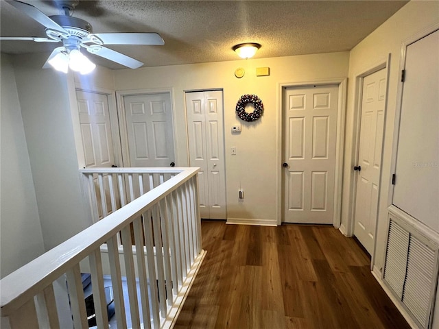 corridor featuring dark hardwood / wood-style flooring and a textured ceiling