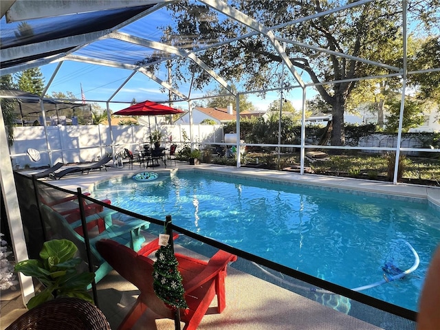 view of pool featuring glass enclosure and a patio area