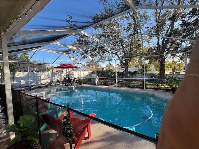 view of swimming pool with a lanai and a patio