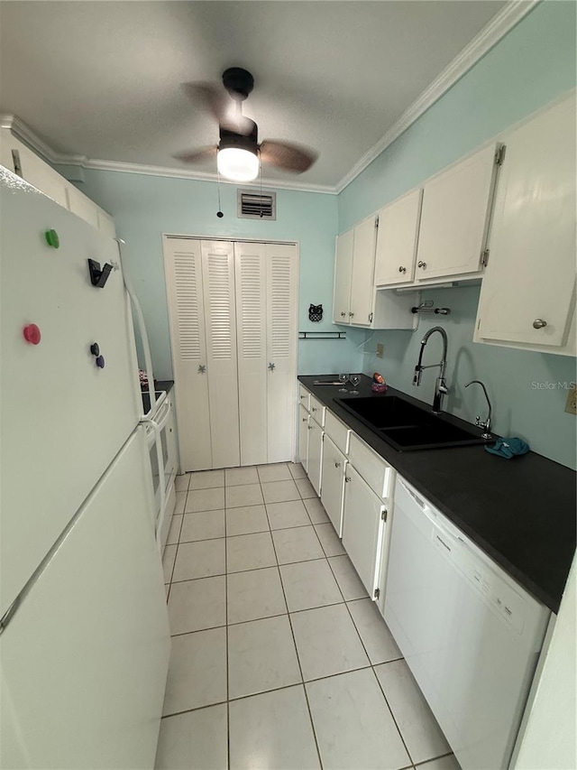 kitchen with white appliances, dark countertops, ornamental molding, white cabinetry, and a sink