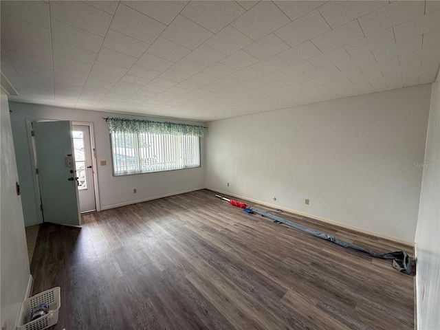 interior space featuring dark wood-style flooring, visible vents, and baseboards