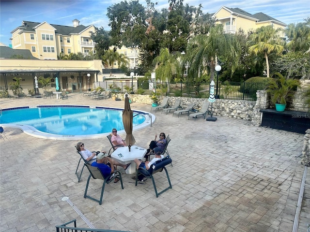 pool with a patio area and fence