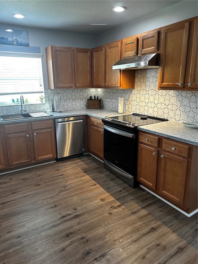 kitchen with dishwasher, electric range oven, sink, dark wood-type flooring, and light stone countertops