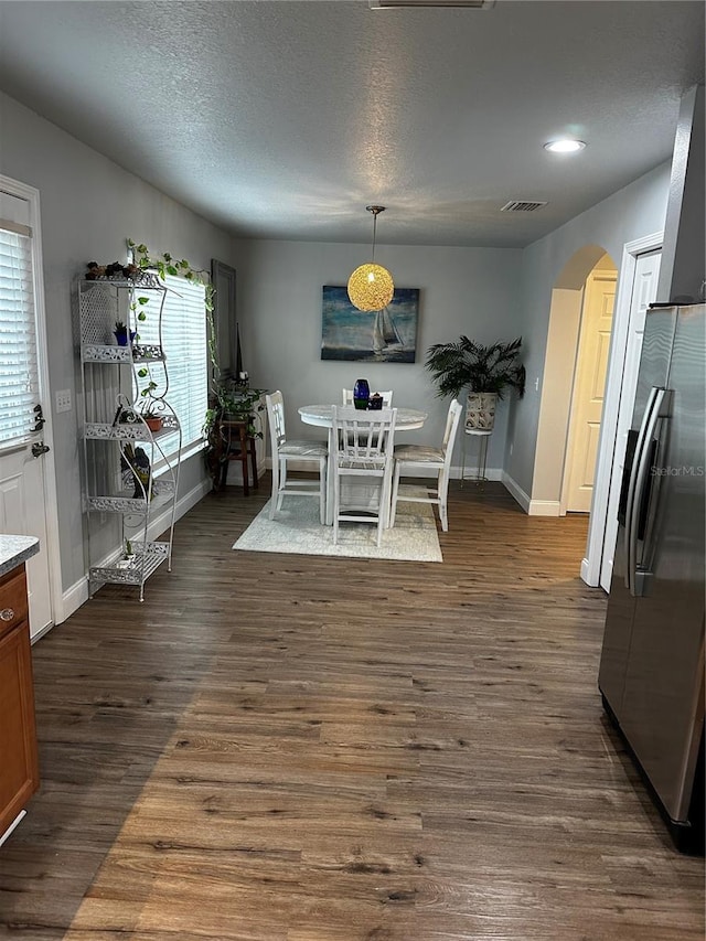 dining area featuring dark hardwood / wood-style flooring and a textured ceiling