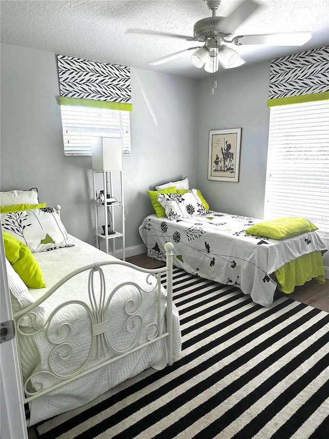 bedroom featuring a textured ceiling, ceiling fan, and hardwood / wood-style floors