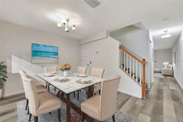 dining room with light hardwood / wood-style flooring and a chandelier