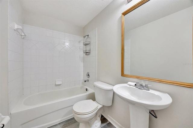 bathroom featuring tiled shower / bath combo, toilet, and wood-type flooring