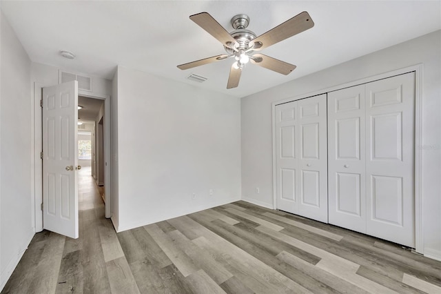 unfurnished bedroom featuring light wood-type flooring, a closet, and ceiling fan