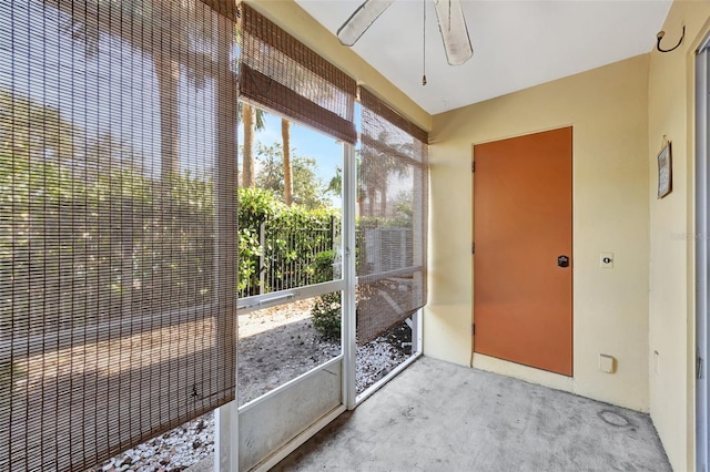 unfurnished sunroom featuring ceiling fan