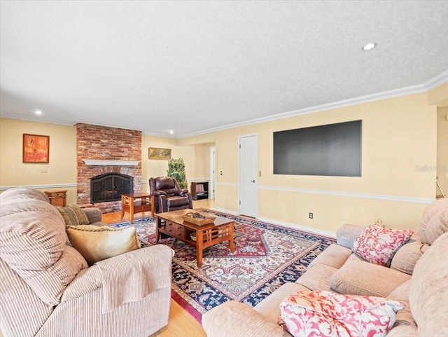 living room featuring crown molding, a fireplace, a textured ceiling, and hardwood / wood-style flooring